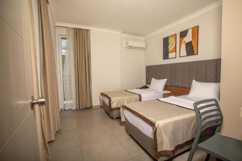 a hotel room with two beds and a table at Perle Apart Hotel in Alanya