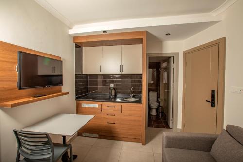 a small kitchen with a table and a couch at Perle Apart Hotel in Alanya