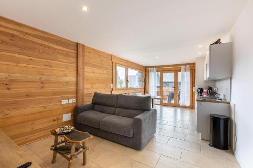 un salon avec un canapé et une cuisine dans l'établissement Le Cocon du Lac - Vue montagnes, aux Angles