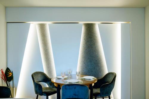 a dining room with a table and four chairs at The QUARK Modern Designed 2BR Central Apartment in Craiova
