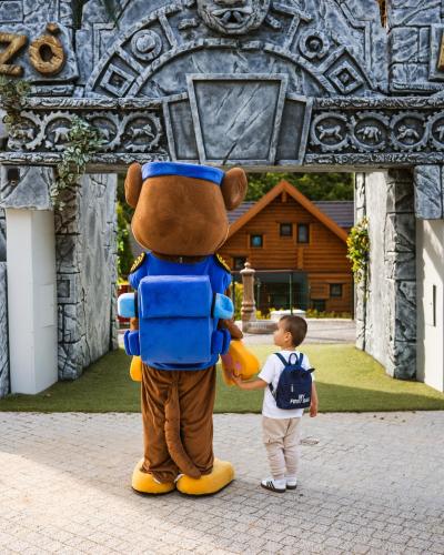 a young boy standing next to a teddy bear mascot at Avalon Resort & SPA in Miskolctapolca