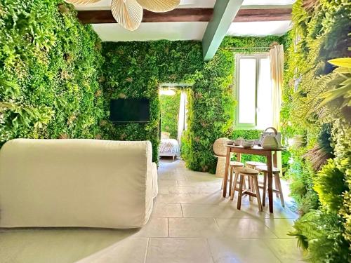 un salon avec un mur végétal avec une table et des chaises dans l'établissement Logement insolite classé - Nîmes Arènes - Parking, à Nîmes