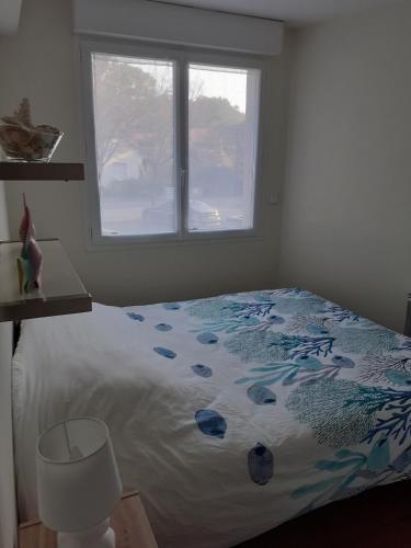 une chambre avec un lit et une fenêtre dans l'établissement le Colisée appartement vue mer, à La Baule