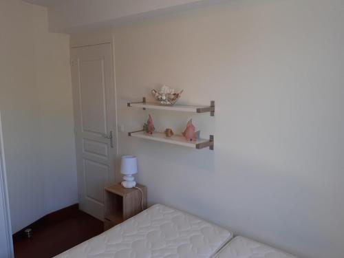 - une chambre avec un lit et des étagères sur le mur dans l'établissement le Colisée appartement vue mer, à La Baule