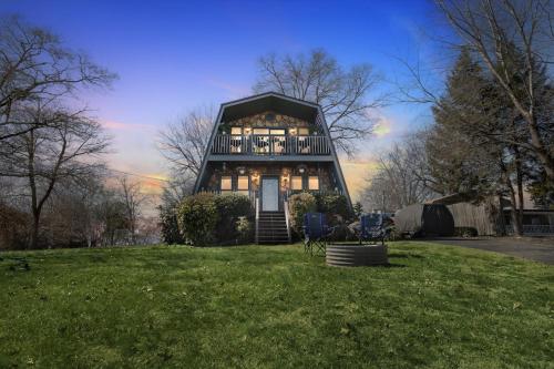 a house on a grassy field with two chairs at Beautiful Lakeview Chateau with Stunning Views home in Rutledge