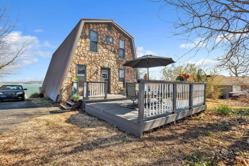 a stone house with a porch and an umbrella at Beautiful Lakeview Chateau with Stunning Views home in Rutledge