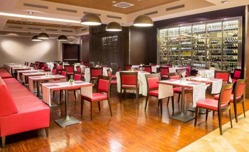 a dining room with tables and red chairs at Best Western Premier BHR Treviso Hotel in Quinto di Treviso