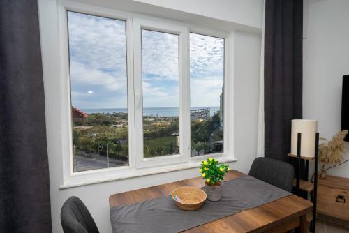 a dining room with a table and two windows at B lackstone Homes in Aksu