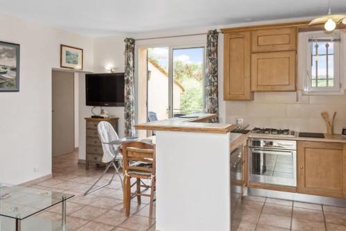 - une cuisine avec un comptoir et une table dans une pièce dans l'établissement La Frênaie - Quiet - Swimming pool - Car park, à Villeneuve-Loubet