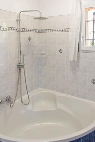 La salle de bains est pourvue d'une baignoire blanche et d'une douche. dans l'établissement La Frênaie - Quiet - Swimming pool - Car park, à Villeneuve-Loubet