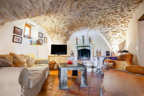 un salon avec un canapé et une cheminée dans l'établissement Maison authentique en Drôme Provençale, à Montréal-les-Sources