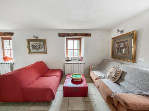 un salon avec un canapé rouge et une table dans l'établissement Maison authentique en Drôme Provençale, à Montréal-les-Sources