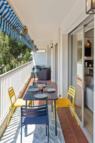 un patio avec une table et des chaises sur un balcon dans l'établissement Le Mimosa - Calm - Spacious - 200m from the sea - Parking, à Cagnes-sur-Mer