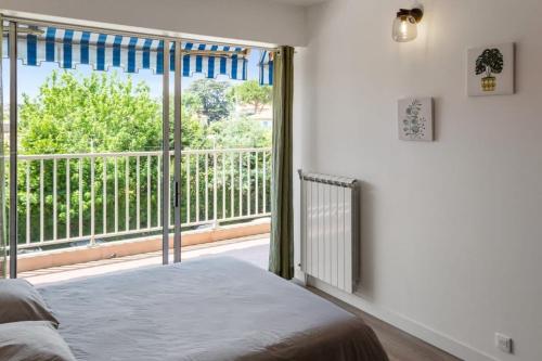 une chambre avec un lit et une grande fenêtre dans l'établissement Le Mimosa - Calm - Spacious - 200m from the sea - Parking, à Cagnes-sur-Mer