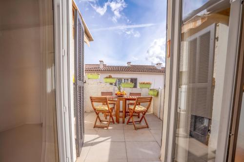 un patio avec une table et des chaises sur un balcon dans l'établissement L'Échappée Bleue, à Saint-Cyr-sur-Mer