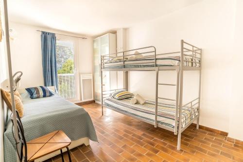 une chambre avec deux lits superposés et une fenêtre dans l'établissement L'Échappée Bleue, à Saint-Cyr-sur-Mer