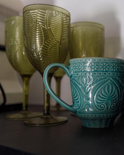 a blue vase and two glasses on a table at Apartments Castello Risano in Risan