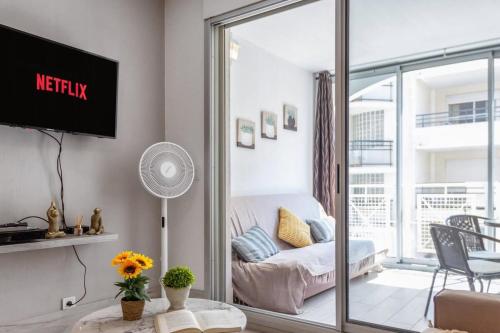 un salon avec une télévision et un canapé dans l'établissement Le Bricka - Hypercentre - Cosy - 2 min from the sea, à Antibes