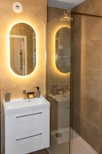 une salle de bain avec un lavabo blanc et une douche dans l'établissement Le Bricka - Hypercentre - Cosy - 2 min from the sea, à Antibes