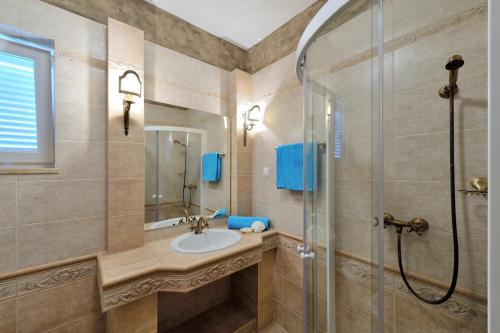 a bathroom with a sink and a shower at Vila Mila sa privatnim bazenom in Medulin