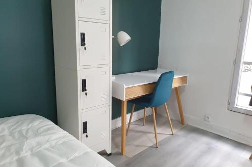 - une chambre avec un bureau et une chaise bleue dans l'établissement Flexliving - studio - Auriol, à Paris
