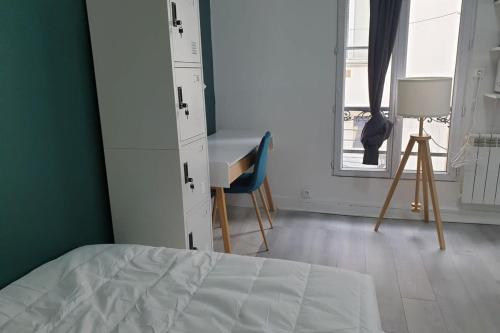 une chambre avec un lit, un bureau et une fenêtre dans l'établissement Flexliving - studio - Auriol, à Paris