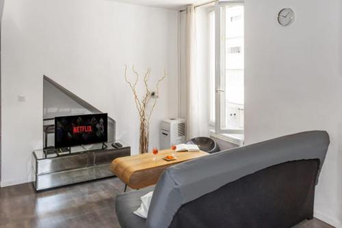 un salon avec un canapé, une table et une télévision dans l'établissement Le Montfleury - Hypercenter - Cozy - WIFI, à Cannes