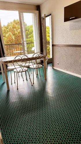 une chambre avec deux chaises et un banc sur un balcon dans l'établissement Argeles sur Mer Charmant T2 a 150m de la plage, à Argelès-sur-Mer