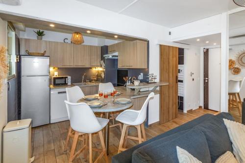 a kitchen and a living room with a table and chairs at Le Pied Dans L'eau - Calm - Sun - Seaside - Hipprodrome - Racetracks in Cagnes-sur-Mer