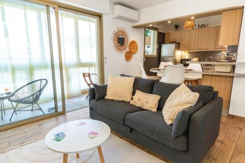 a living room with a couch and a kitchen at Le Pied Dans L'eau - Calm - Sun - Seaside - Hipprodrome - Racetracks in Cagnes-sur-Mer