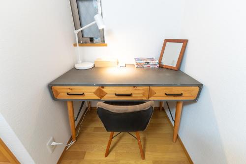 a desk with a mirror and a chair in a room at Guest House Kubo Homes Shotenshita in Osaka