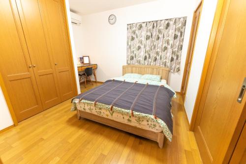 a bedroom with a bed and a wooden floor at Guest House Kubo Homes Shotenshita in Osaka