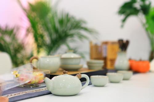 a table with cups and a tea pot on it at Perfect holiday inn in Yangshuo