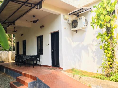 a patio of a house with a table and chairs at ILLIKKALAM Lakeside Cottages Kumarakom Kerala in Kumarakom