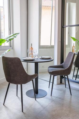 une salle à manger avec une table et deux chaises dans l'établissement Le Joffre - Hypercentre - 200m Palais - AC, à Cannes