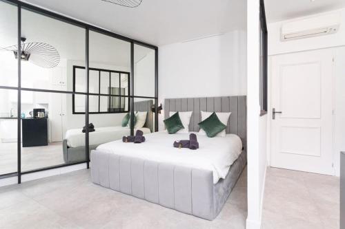 une chambre avec un grand lit blanc et un miroir dans l'établissement Le Joffre - Hypercentre - 200m Palais - AC, à Cannes