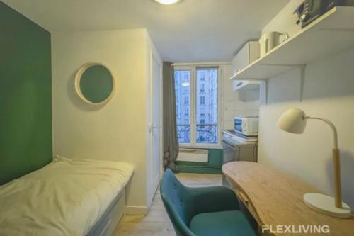Cette petite chambre comprend un lit, une table et une chaise. dans l'établissement Flexliving - Studio - Saint Martin, à Paris