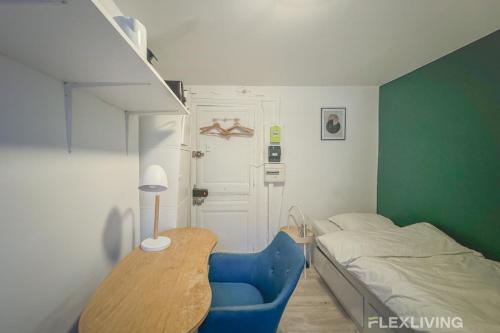- une petite chambre avec un lit et une chaise bleue dans l'établissement Flexliving - Studio - Saint Martin, à Paris