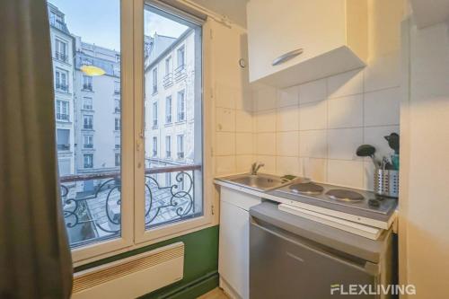 une cuisine avec un évier et une fenêtre dans l'établissement Flexliving - Studio - Saint Martin, à Paris