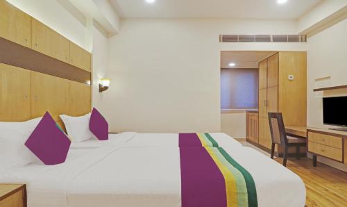 a bedroom with a large white bed and a desk at Treebo Premium Seven Lake View in Hyderabad