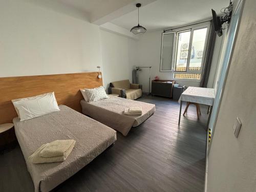 a small room with two beds and a chair at Cc39-Q2 in Funchal