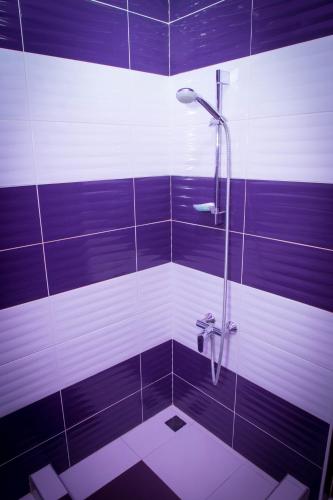 a bathroom with a shower with purple and white stripes at Palazzo Hotel in Yerevan