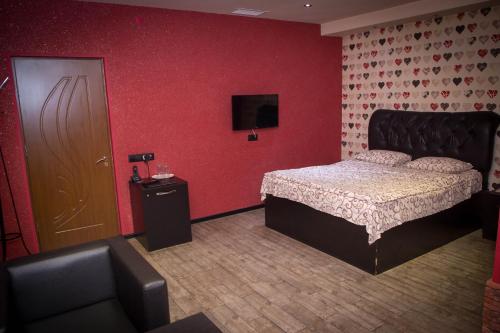 a bedroom with a bed and a red wall at Palazzo Hotel in Yerevan