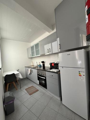 a kitchen with a white refrigerator and a table at Cc39-Q2 in Funchal