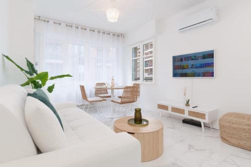 un salon blanc avec un canapé blanc et une table dans l'établissement Le Maubourg - Hypercentre - 150m Croisette - AC, à Cannes