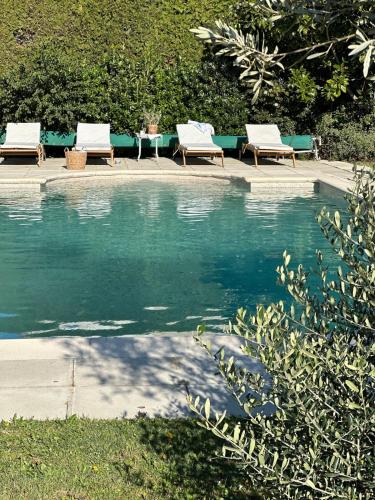 2 chaises et un bassin d'eau avec bancs dans l'établissement Le Lagon Vert, à Pernes-les-Fontaines