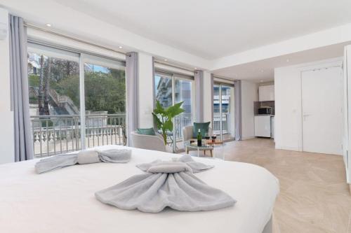 - une chambre blanche avec un grand lit blanc et de grandes fenêtres dans l'établissement Le Louis Blanc - Hypercentre - 100m Suquet - AC, à Cannes