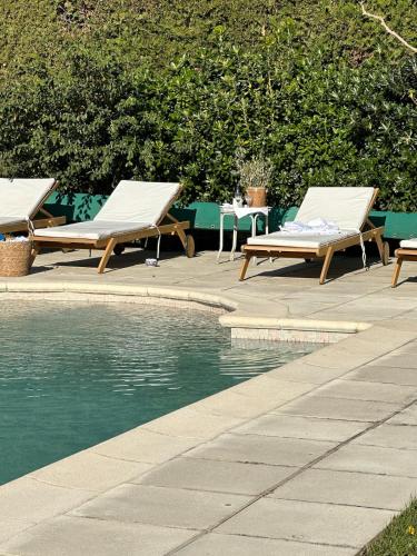 deux chaises longues assises à côté d'une piscine dans l'établissement Le Lagon Vert, à Pernes-les-Fontaines