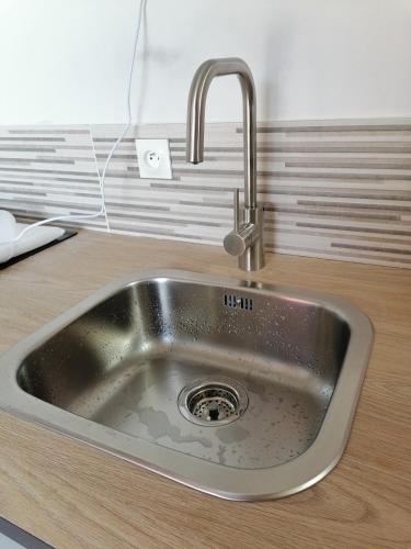 - un évier de cuisine avec un robinet sur un comptoir dans l'établissement Studio du Clos, à Yvetot