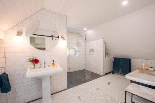 a white bathroom with two sinks and a shower at The Old School Historic Stay for 2 Adelaide Hills in Balhannah